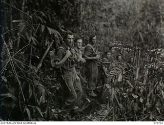 Pearl Ridge, Bougainville. 1945-03-07. N130687 Private W. C. Jones and NX155478 Private A. L. McDonald of a reconnaissance patrol from the Far Eastern Liaison Office (FELO) turn to look at the ..