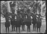 Boys posing in grass skirts, with waist and head piece