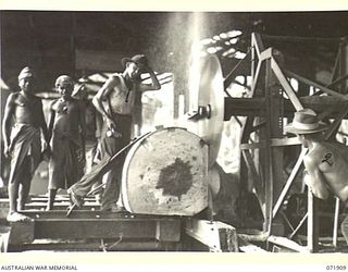 LAE, NEW GUINEA. 1944-03-30. VX144654 SAPPER J. O'BRIEN (1), WITH Q138515 SAPPER J. OAKWOOD (2), SQUARING OR "BREAKING DOWN" LOGS WITH A TWIN 66" CANADIAN SAW IN A SAWMILL AT 59TH CORPS FIELD PARK ..