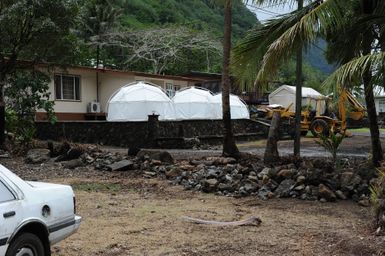 Earthquake ^ Flooding ^ Tsunami - Pago Pago, American Samoa, October 15, 2009 -- Heavy machinery sits in front of home to help with repairs while the family takes refuge at night in three tents. The Federal Emergency Management Agency provided tents following the earthquake, tsunami and flooding that swept the area. David Gonzalez/FEMA