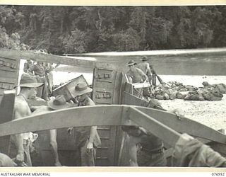 JACQUINOT BAY, NEW BRITAIN. 1944-11-12. TROOPS OF THE MORTAR PLATOON, 14/32ND INFANTRY BATTALION UNLOADING THEIR STORES AND AMMUNITION AT THE 1ST NEW GUINEA INFANTRY BATTALION BEACH-HEAD IN MARAU ..