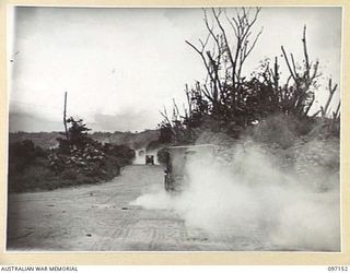 RABAUL, NEW BRITAIN. 1945-09-25. A JEEP CARRYING PERSONNEL OF 5 MILITARY HISTORY FIELD TEAM, RAISING DUST ON THE MALAGUNA ROAD, THE MAIN HIGHWAY. DUSTY ROADS ARE A PROBLEM IN THE RABAUL AREA