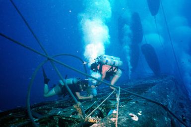 Underwater view of two Navy divers working to raise the submarine ex-USS BLUEGILL (SS 242) during Pacific Submarine Salvage Exercise 83 (PACSUBSALVEX-83) off the coast of Maui