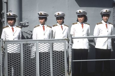 Uniformed members of the cultural troupe embarked aboard the Chinese navy training vessel Zheng He stand aboard the ship during a ceremony marking the ship's arrival. The Zheng He is in Hawaii for a cultural exchange visit