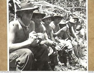 FARIA RIVER, RAMU VALLEY, NEW GUINEA. 1944-01-18. MEMBERS OF D COMPANY, 2/9TH INFANTRY BATTALION PAUSE FOR A SMOKE DURING THEIR BRIDGE BUILDING OPERATIONS OVER THE FARIA RIVER. IDENTIFIED PERSONNEL ..