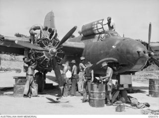 Informal portrait of ground crew of No. 22 (Boston) Squadron RAAF at Kiriwina with an aircraft stripped for an inspection. Identified from left to right: Sergeant A Edmond from Newcastle, NSW; ..