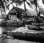 Beached canoes in slip beside reclamation extending into the lagoon.