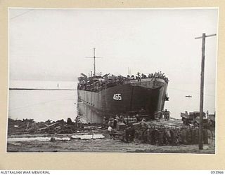 PALMALMAL PLANTATION, JACQUINOT BAY, NEW BRITAIN, 1945-07-09. A UNITED STATES LANDING SHIP, TANK (LST) WITH ITS FRONT DOORS OPENING TO DISCHARGE PERSONNEL, STORES AND EQUIPMENT FOR THE ROYAL NEW ..