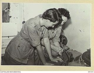 LAE, NEW GUINEA, 1945-05-07. CORPORAL N.I. HARRISON (1), AND CORPORAL W. HARVEY (2), PACKING CASES IN THEIR CABIN BEFORE DISEMBARKATION BY LIGHTER FROM THE MV DUNTROON. THEY ARE PART OF A GROUP OF ..