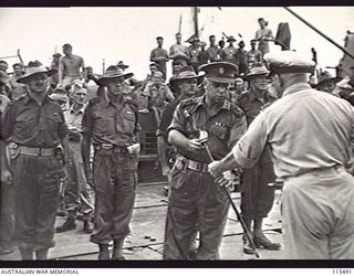 TOROKINA, BOUGAINVILLE. 1945-09-08. BRIGADIER J. FIELD, COMMANDER, 7TH INFANTRY BRIGADE, RECEIVING A JAPANESE OFFICER'S SWORD FROM COMMANDER A. E. FOWLER, RAN, AT THE PONTOON WHARF PRIOR TO MOVING ..