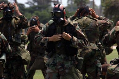 US Navy Builder 2nd Class Robert Burig from Naval Mobile Construction Battalion 3, Port Hueneme, Calif., and members of his squad don their flak vests and gas masks during a field exercise in Guam. More than 350 USN Seabees participated in the event designed to demonstrate their abilities in combat environment. (U.S. Navy photo by Mass Communication SPECIALIST 1ST Class Carmichael Yepez) (Released)