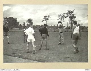 LAE, NEW GUINEA. 1944-10-01. VX104118 MAJOR R.C. UPSON, OFFICER COMMANDING, 22ND WORKS COMPANY, BOUNCES THE BALL DURING AN AUSTRALIAN RULES FOOTBALL MATCH ON THE NEW SPORTS OVAL