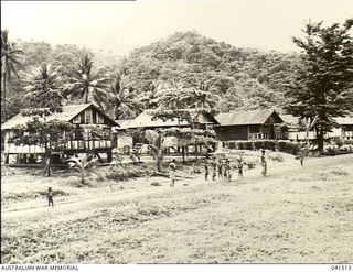 Milne Bay, Papua. 1949-08. War salvaged materials have been utilised by Papuans in building their houses which look like part of a housing estate. This photograph was taken seven years after World ..