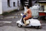 French Polynesia, women riding scooter in Papeete