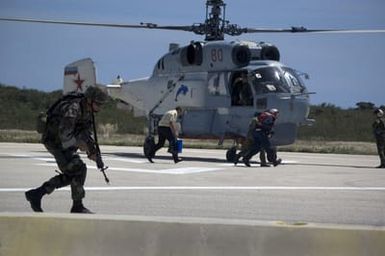 A US Navy (USN) Sailor assigned to Mobile Security Squadron 7 (MSS-7), armed with 5.56 mm M4 carbines, equipped with blank firing devices, provide security as Exercise participants board a Russian Federated Navy (RFN) KA-27 Helix helicopter at Santa Rita Naval Base, Guam (GU), during a joint humanitarian assistance, disaster relief exercise. RFN ships are participating in Passing Exercise 2006 (PASSEX 06) with USN ships off the coast of Guam. The Exercise is designed to increase interoperability between the two navies while enhancing the strong cooperative relationship between Russia and the US