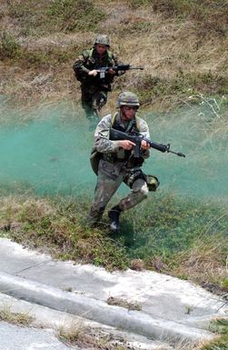 With 5.56 mm M16A2 rifles, US Marine Corps (USMC) Marines from 3rd Platoon (PLT), Fox Company, 2nd Battalion (BN), 4th Marine Regiment (MAR RGT), Marine Corps Base (MCB) Camp Pendleton, California (CA), conduct urban terrain combat training. The training is taking place in a former US Air Force (USAF) housing area near Anderson Air Force Base (AFB), Guam, during joint Exercise TANDEM THRUST 2003