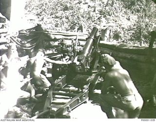 THE SOLOMON ISLANDS, 1945-01-12. AN AIF GUNCREW FIRING A 25 POUND GUN. (RNZAF OFFICIAL PHOTOGRAPH.)