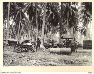 AITAPE AREA, NEW GUINEA, 1944-11-12. TROOPS OF 135 BRIGADE WORKSHOP IN THE FOREGROUND ERECT A TANK STAND FOR SHOWERS. AT THE LEFT BACKGROUND MEMBERS ERECT A TEMPORARY SHELTER FOR A SPARE PARTS ..