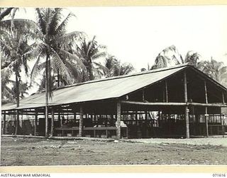 LAE, NEW GUINEA. 1944-03-24. THE GENERAL ENGINEERING BUILDING AT THE AUSTRALIAN FORTRESS WORKSHOP HOUSING THE GENERAL ENGINEERING, ARMAMENT, ARMOURY, BLACKSMITH, CARPENTERS, WOOD MACHINISTS AND ..