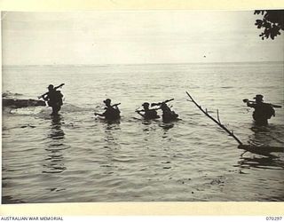WEBER POINT, NEW GUINEA, 1944-02-09. "D" COMPANY, 30TH INFANTRY BATTALION MEMBERS CROSSING THE RIVER ON A SANDBAR NEAR WEBER POINT, IN THE ADVANCE FROM ROINJI (2) TO LINK WITH AMERICAN TROOPS AST ..