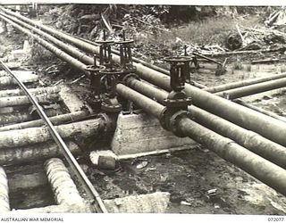 MILNE BAY, NEW GUINEA. 1944-04-04. A SET OF VALVE AND PIPELINE JUNCTIONS AT THE 2ND AUSTRALIAN BULK PETROLEUM STORAGE COMPANY