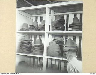 LAE, NEW GUINEA. 1944-09-27. NEW FUR FELT HATS STACKED IN THE RACKS AT THE 43RD FIELD ORDNANCE DEPOT