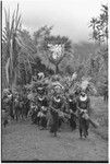 Bride price for Maima: Molo the groom's group dances with payment banner of feather and shell valuables for bride's clan