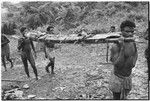 Men carrying in large taro pudding on rack