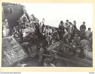 JACQUINOT BAY, NEW BRITAIN. 1945-09-09. TROOPS OF 4 INFANTRY BRIGADE RELAXING IN THE WELL DECK OF HMAS MANOORA. THE MANOORA CARRIED TROOPS FOR THE OCCUPATION OF THE RABAUL AREA, FOLLOWING THE ..