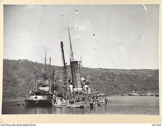 RABAUL, NEW BRITAIN. 1945-09-29. WRECKED JAPANESE SHIPS NEAR VULCAN CRATER. THE SALVAGE BOAT OPERATED BY COMMONWEALTH MARINE SALVAGE BOARD IS WORKING ON A JAPANESE NAVAL TANKER AND SUPPLY VESSEL ..