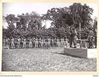 TOROKINA, BOUGAINVILLE. 1945-09-24. MAJOR GENERAL W. BRIDGEFORD, GENERAL OFFICER COMMANDING 3 DIVISION, PINNING THE MILITARY MEDAL ON PRIVATE L. YAURIE, AT A PRESENTATION OF AWARDS AND MARCH PAST ..