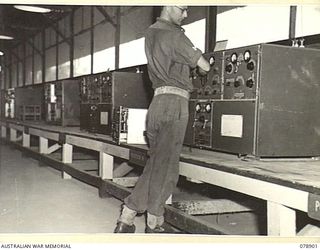 LAE, NEW GUINEA. 1945-02-06. Q108994 CORPORAL C.W. THOMPSON, 19TH LINES OF COMMUNICATION SIGNALS, HEADQUARTERS, FIRST AUSTRALIAN ARMY TUNING A 133 RADIO SET IN THE MAIN WIRELESS TRANSMITTING CENTRE ..