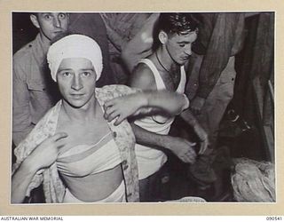 JACQUINOT BAY, NEW BRITAIN. 1945-04-15. SAPPER R.V. COOPER (1), AND SERGEANT V. MCVEIGH (2), PREPARING TO TAKE PART IN A CONCERT STAGED BY MEMBERS OF 33 DOCKS OPERATING COMPANY, ROYAL AUSTRALIAN ..