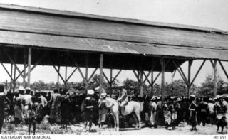 RABAUL, NEW BRITAIN. C. 1916. A BUSY DAY AT THE NATIVE MARKET. THE HORSEMAN IS CAPTAIN FOULKES, ACTING COMMANDER NATIVE AFFAIRS