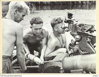 1943-09-25. NEW GUINEA. ADVANCE ON LAE. AUSTRALIAN 25 POUNDERS BEING LOADED. LEFT TO RIGHT - GNR. F. REID OF NORTH MELBOURNE, VIC., GNR. B. WOOD, OF BRIGHTON, VIC., AND GNR. A. ROBERTSON OF ..