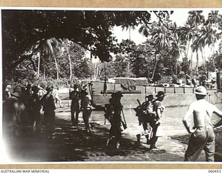 FINSCHHAFEN AREA, NEW GUINEA. 1943-11-09. UNLOADING SUPPLIES AND TROOPS AT KEDAM BEACH, THE MAIN SUPPLY POINT FOR THE 870TH UNITED STATES ENGINEER AVIATION BATTALION. THIS UNIT IS PREPARING THE ..