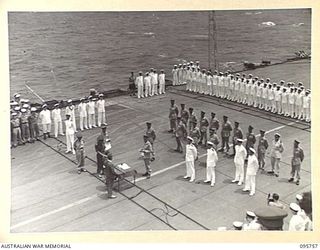 AT SEA OFF RABAUL, NEW BRITAIN. 1945-09-06. THE SURRENDER CEREMONY ON BOARD THE AIRCRAFT CARRIER HMS GLORY. LIEUTENANT GENERAL V.A.H. STURDEE, GENERAL OFFICER COMMANDING FIRST ARMY READS SURRENDER ..