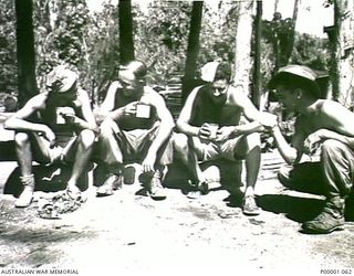 THE SOLOMON ISLANDS, 1945-02-26. A GROUP OF AUSTRALIAN AND NEW ZEALAND SERVICEMEN AT THEIR CAMP AREA ON BOUGAINVILLE ISLAND. (RNZAF OFFICIAL PHOTOGRAPH.)