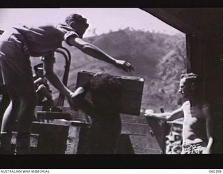 17 MILE, LALOKI RIVER, NEW GUINEA. 1943-11-22. UNIT VEHICLE COLLECTING CORDIALS AT THE FACTORY ESTABLISHED AND OPERATED BY THE AUSTRALIAN DEFENCE CANTEEN SERVICES ATTACHED TO HEADQUARTERS, NEW ..