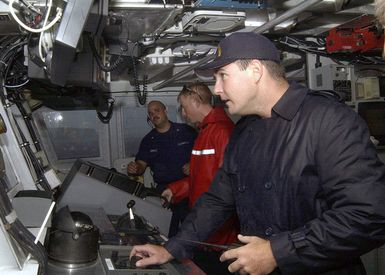 On the bridge of the US Coast Guard (USCG) Island Class; Patrol Craft, GALVESTON ISLAND (WPB 1349), crewmembers keep watch during a driving rainstorm, while conducting escort operation into Apra Harbor, Guam. Pictured foreground-to-background are Commanding Officer, Lieutenant (LT) Jerome E. Dubay; PETTY Officer Second Class (PO2) Jeremy Demello; and Executive Officer, Lieutenant Junior Grade (LTJG), Collin MacInnes