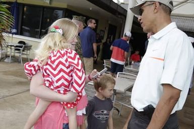 Barack Obama greets military personnel before playing golf in Kaneohe Bay, Hawaii, December 24, 2014