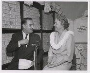 Priest, right, with Jack Benson, commentator for KGMB-TV, with Bishop National Bank of Hawaii bags in background, on May 6, 1959