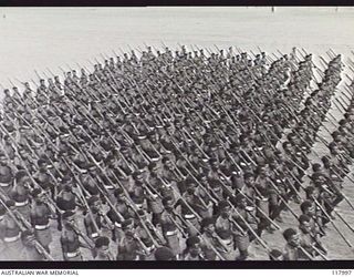 TOROKINA, BOUGAINVILLE. 1945-10-29. MEMBERS OF THE PAPUAN INFANTRY BATTALION MOVING TOWARDS THE SALUTING BASE WHERE THE COMMANDER IN CHIEF, AUSTRALIAN MILITARY FORCES, IS TAKING THE SALUTE DURING A ..