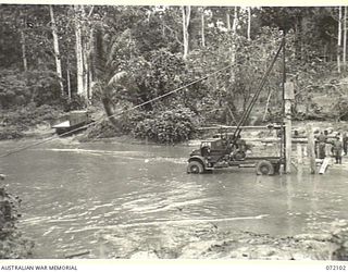 KILIGIA, NEW GUINEA. 1944-04-04. A BRIDGE IN CONSTRUCTION ACROSS THE SOWI RIVER BY THE ROYAL AUSTRALIAN ENGINEERS. THE BRIDGE REPLACES USE OF THE FORD TRACK WHICH CLIMBS THE SOUTH BANK OF THE RIVER ..