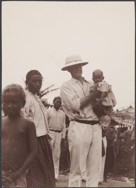 Bishop Wilson holding a baby and talking to boys at Buala, Solomon Islands, 1906 / J.W. Beattie