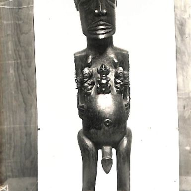 Photo of carving of a Tangaroa with three smaller figures on his chest (XIX/38)