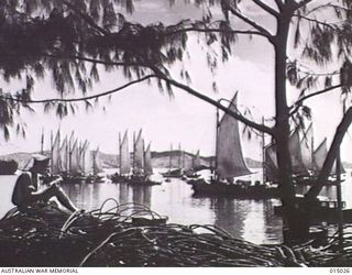 1943-06-16. NEW GUINEA. AFTER A TYPICAL MORESBY RAIN STORM, SAILING CRAFT SPREAD THEIR CANVAS TO DRY OFF IN THE MORNING SUN. IN THIS PICTURESQUE SETTING DRIVER N.J. COSSINS OF HIGHGATE HILL, ..