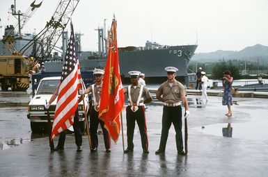 A Marine Corps color guard stands at parade rest while participating in a welcoming ceremony for the combat stores ship USS NIAGARA FALLS (AFS 3) at Naval Station Guam