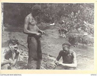 BOUGAINVILLE ISLAND. 1945-03-01. VX101523 SIGNALLER A. VITIRITTI (1), VX144869 SIG. O.E. PITT (2) AND VX77379 SIG. E. ROTHERHAM (3), 3RD DIVISION SIGNALS, REPAIRING AND TESTING SIGNAL LINES WHICH ..