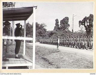 TOROKINA, BOUGAINVILLE. 1945-09-24. TROOPS OF A COMPANY, 24 INFANTRY BATTALION, 15 INFANTRY BRIGADE, SALUTING AS THEY PASS THE SALUTING BASE DURING THE MARCH PAST AT A PARADE HELD AT GLOUCESTER ..